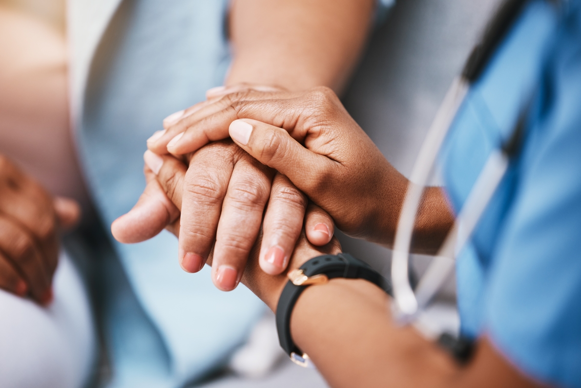 Caregiver holding patient's hand