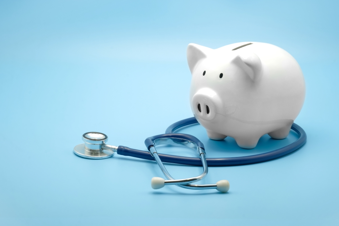 Stethoscope laying around a piggy bank