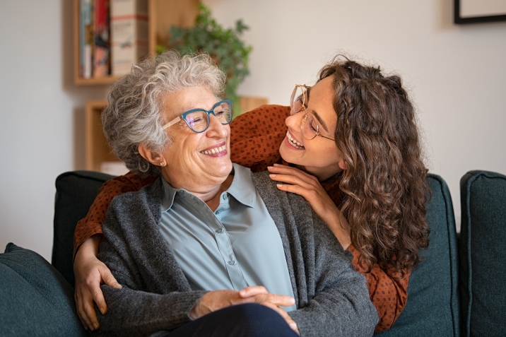 Mother and adult daughter smiling at one another