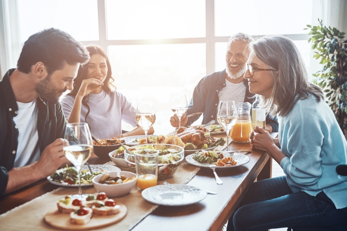 Multigenerational family having a conversation and laughing over a meal