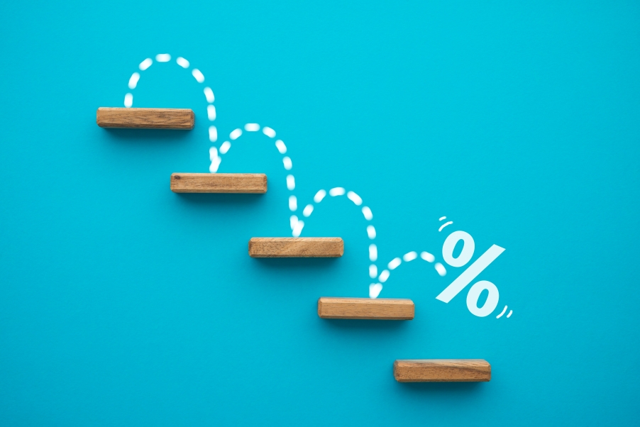 Percentage sign bouncing down steps, symbolizing an interest rate cut